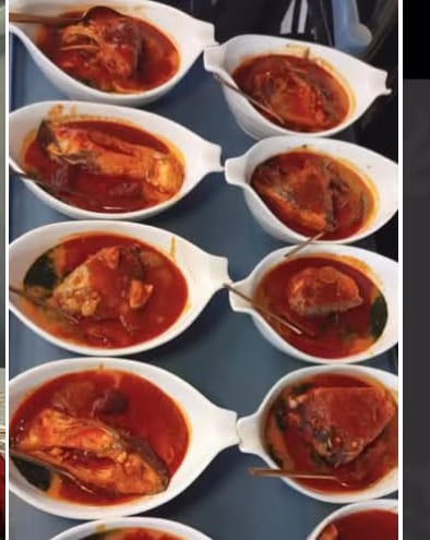Rows of fish stew servings plated for guests at an event