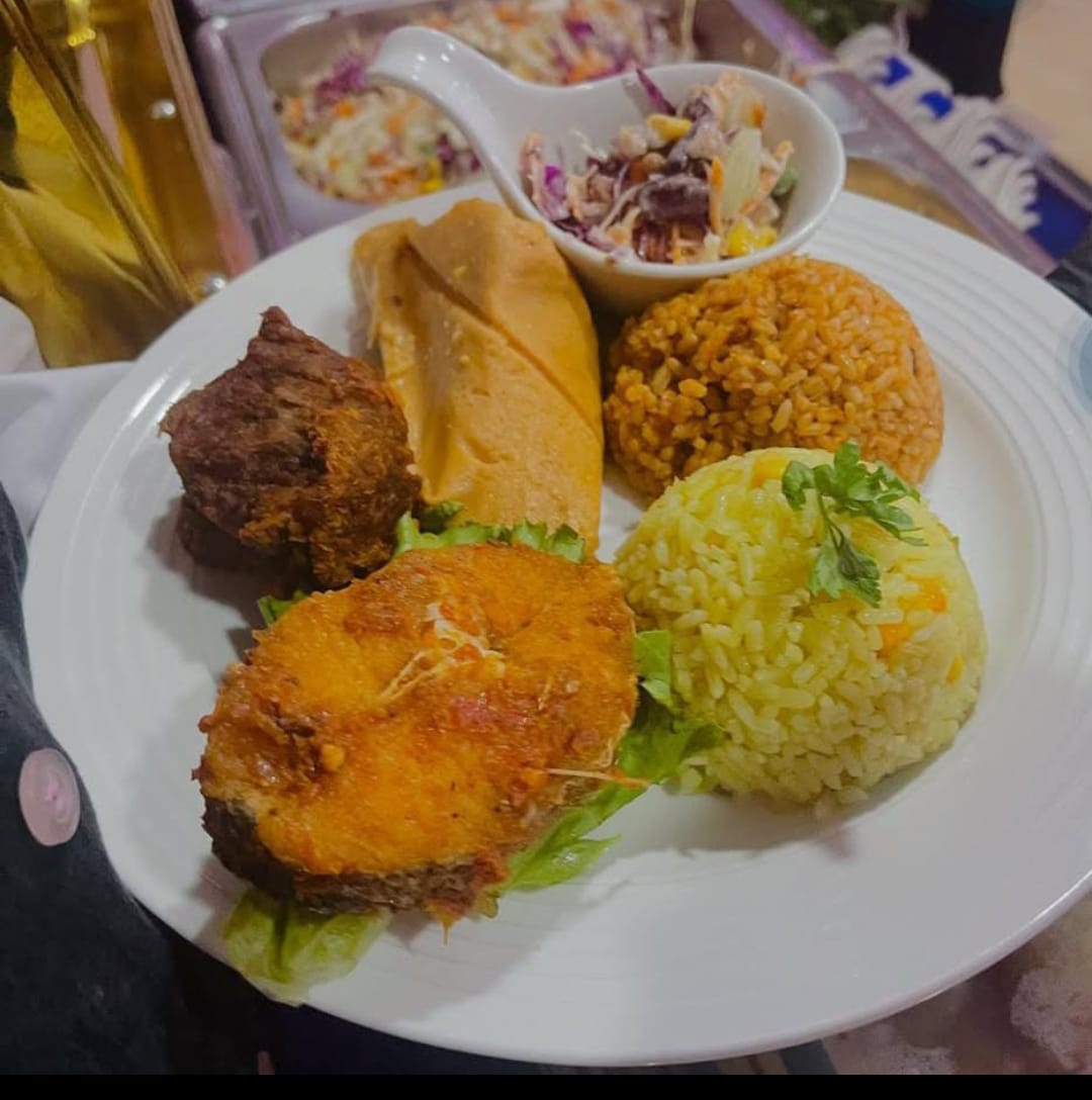 Event plate of jollof rice, fried rice, fish, moin moin and coleslaw