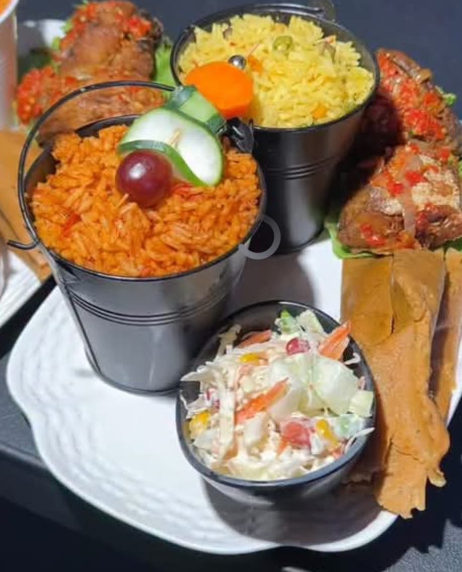 Jollof and fried rice in mini buckets with coleslaw and grilled chicken